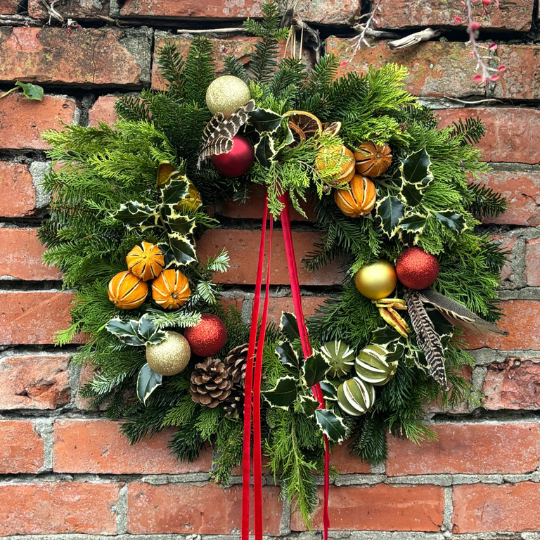Holly Door Wreath in red and gold with pheasant feathers, dried limes and red ribbon. Available for delivery in Darlington and Nationwide